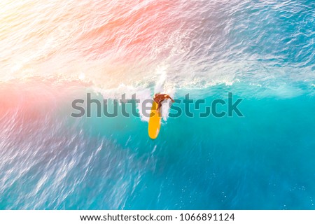 Surfer on a yellow surfboard in the ocean on a sunny day Royalty-Free Stock Photo #1066891124