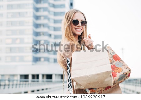 Attractive young woman with shopping bags making selfie