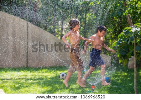Two siblings playing with water