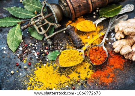 Asian spices on dark table background. Curry, turmeric, ginger, bay leaf. Healthy organic food. Vintage style toned picture