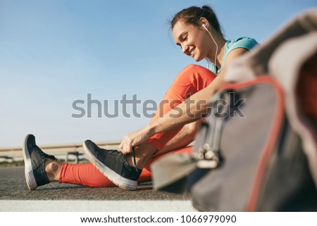 Female runner tying her shoes preparing for a jogging