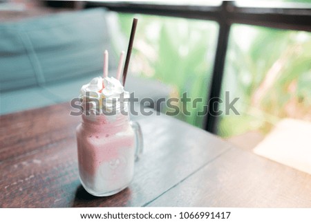 A cup of strawberry smoothie yogurt on a wooden table