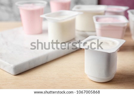 Plastic cup with tasty yogurt on table Royalty-Free Stock Photo #1067005868
