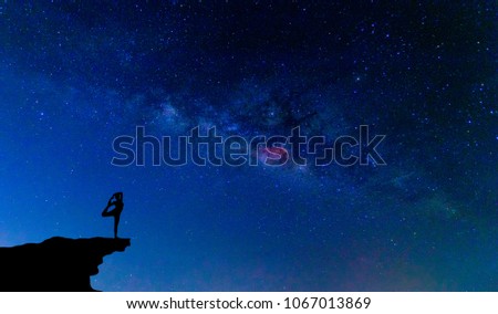 Yoga on the mountain and milky way galaxy at night sky .
