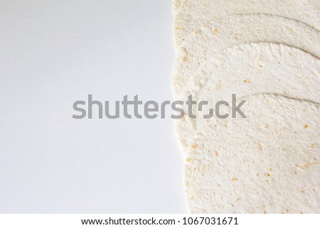 Half picture with wheat tortillas at white background