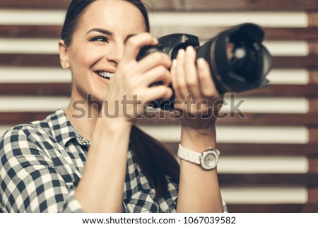 Pretty woman is a professional photographer with dslr camera