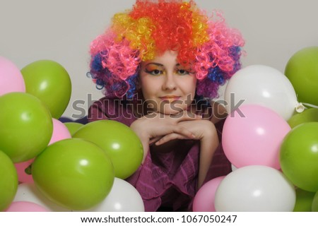 girl in clown wig in studio with balloons