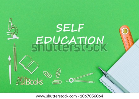 concept school, text self education, school supplies wooden miniatures, notebook, ruler, pen on green backbord