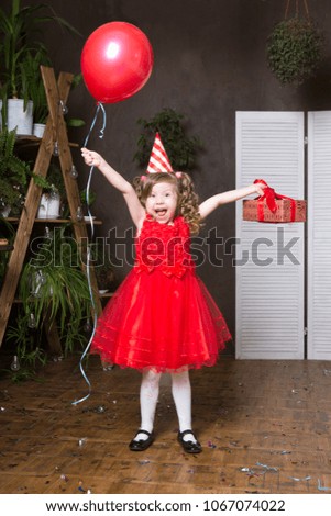 beautiful child  girl  in festive cone cap with multi-coloured balloons and gifts . mother's day. birthday party children.