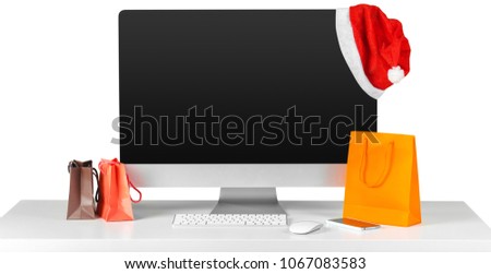 E-commerce concept. Computer monitor screen on table with shopping accessories