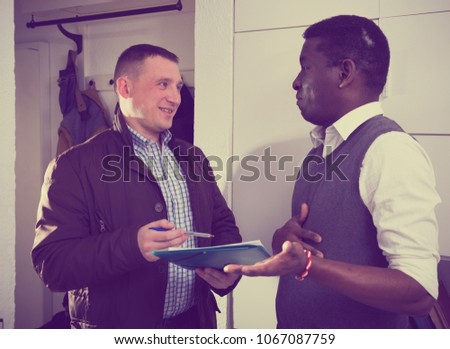 Two international men with documents indoor talk about the services offered