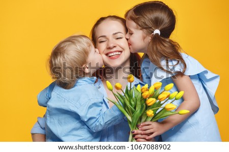 concept of mother's day. mom and children   with flower on colored yellow background