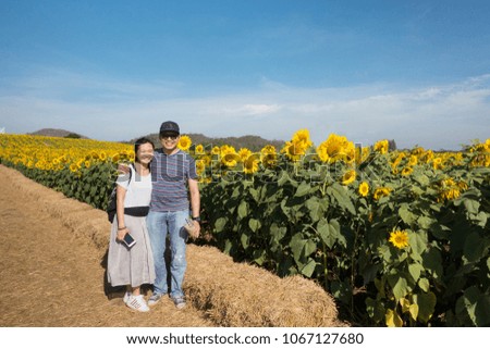 Asian couple adult capture picture with Sunflower flied in Thailand 