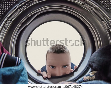 Medium age man looking into the washing machine.