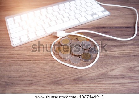 Keyboard and Thai coins on the wooden desk. Work to collect money.