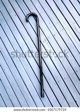 old fashion walking stick cane on a blue wooden deck