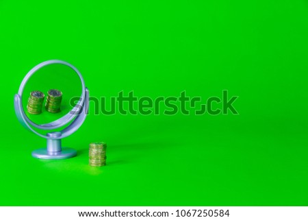 One Pound Coins Stack reflects Two in Mirror. Saving, Spending, Lending Concept on Bright Green Background. Royalty-Free Stock Photo #1067250584