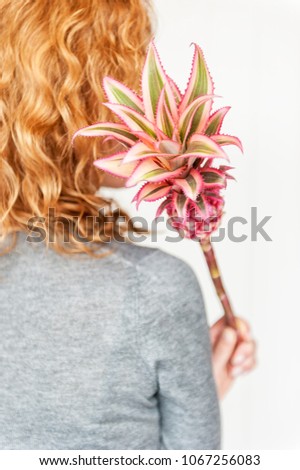 girl holding a pineapple in her hand