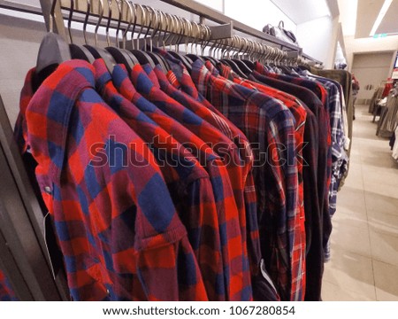 Row of colorful sleeved plaid cotton shirt on hanger on shop 

