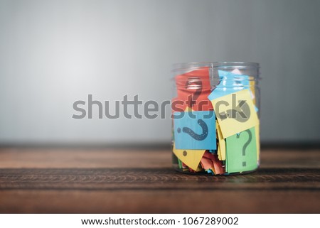 colorful paper with question mark in a plastic jar on wooden table. questions and diversity concept. FAQ and Q&A background concept Royalty-Free Stock Photo #1067289002