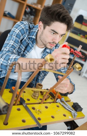 young man apprentice in metalworkshop