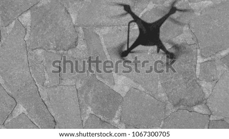 Drone shadow on the ground, downward aerial view.
