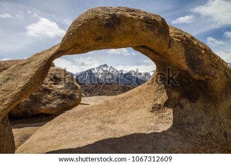 Movie Road, Alabama Hills, Lone Pine, California / USA: Mobius Arch on a lightly cloudy day with snowy Mt. Whitney in Background