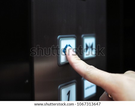 Woman hand press open button  to extend door inside elevator.