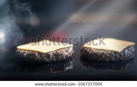 Cooking beef and pork patty with cheese for burger. Meat roasted on fire barbecue kebabs on the grill. Grilled burger cutlet beef minced meat patties or frikadeller in a pan. Street food