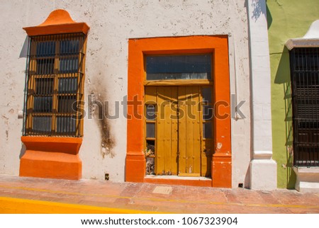 CAMPECHE, MEXICO: Beautiful balcony with a window on the background of the red wall of the house on the street in San Francisco de Campeche.