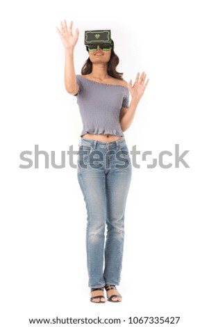 Studio portrait of Asian girl wearing VR headset and experiencing virtual reality