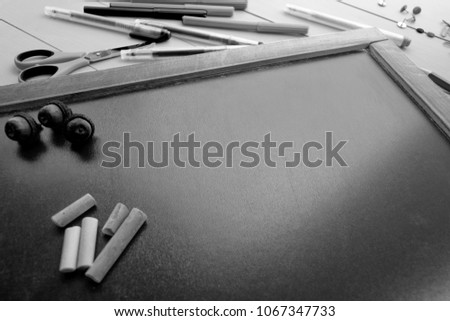 The frame of school supplies (pencils, paints, paper, brushes, markers) on a blackboard. 