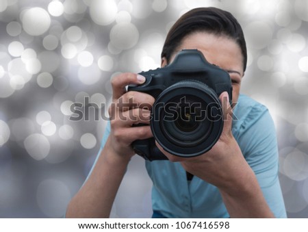 photographer taking a photo (foreground) with silver bokeh background