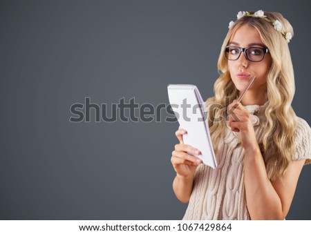 Millennial woman with flowers in hair and notepad against grey background