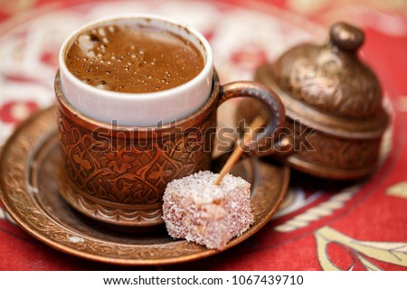 Strong Turkish coffee in a copper Bowl with patterns. Turkish coffee ceremony. Arabic coffee drink. An invigorating drink. Old copper rare dishes for tea.