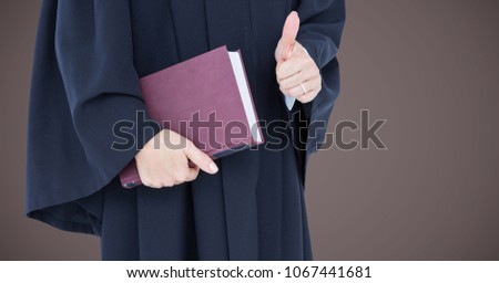 Female judge mid section with book and thumbs up against brown background
