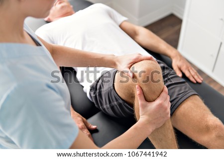 Patient at the physiotherapy doing physical exercises with his therapist Royalty-Free Stock Photo #1067441942