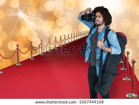 photographer taking a photo in the red carpet. Gold bokeh vbackground