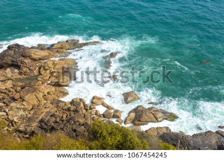 Aerial view of the rocky cliffs and the beach at Kovalam, Kerala, India. Clear turquoise waters from top. Travel photography. Tropical feel at Trivandrum. Eagle flying