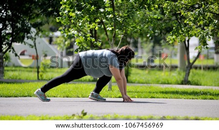 fat woman in the Park running. big size girl doing sports Royalty-Free Stock Photo #1067456969