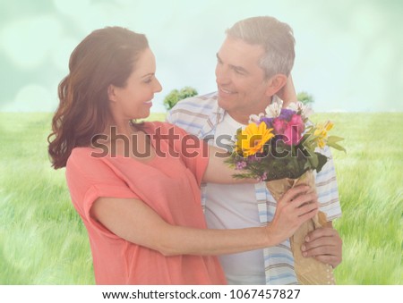 Middle aged couple with flowers in blurry meadow