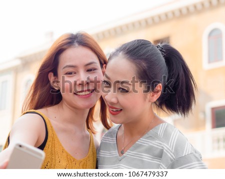 Two Asian tourist women best friends are taking selfie of themselve.