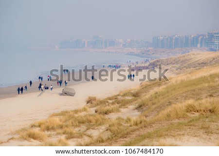 People taking a walk at the beach crossing french-belgium border towards de Panne