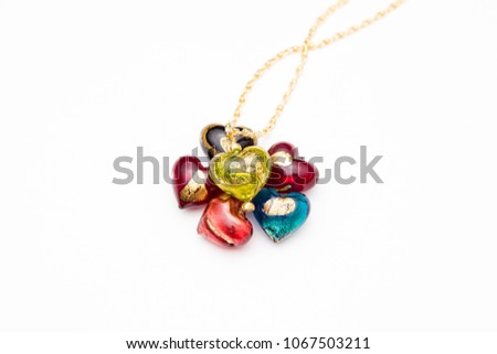 Collection of glass heart shaped beads with a necklace on white background