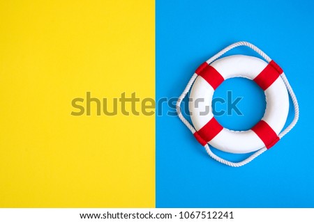 Lifebuoy on a yellow and blue background with blank space for text. Top view travel or vacation concept. Summer background. Flat lay photo, top view Royalty-Free Stock Photo #1067512241