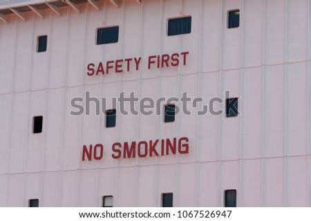 Safety First No Smoking sign on a ship with windows.