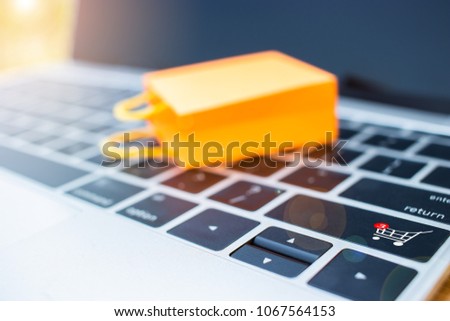 Online shopping concept with trolley icon and symbol on a computer keyboard that allows consumers to directly buy goods or services from a seller over the Internet using a web browser.