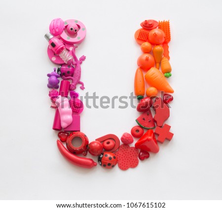 Colorful letter "U" of the toys on a white background. Lots of kids games. Rainbow color Ombre transition.