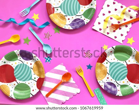 Closeup colorful paper plates,plastic forks & spoons with stars and stripe napkin on pastel pink background.The concept of Birthday party accessories,picnic utensil. Copy space with Selective focus.