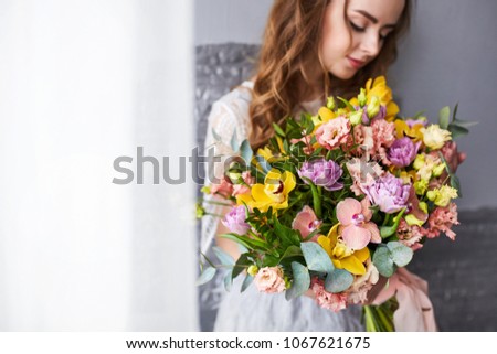 Portrait of a young blonde woman with bouquet. Woman's face with make-up and hairstyle.